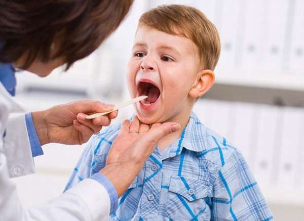 врач осматривает горло ребенка
